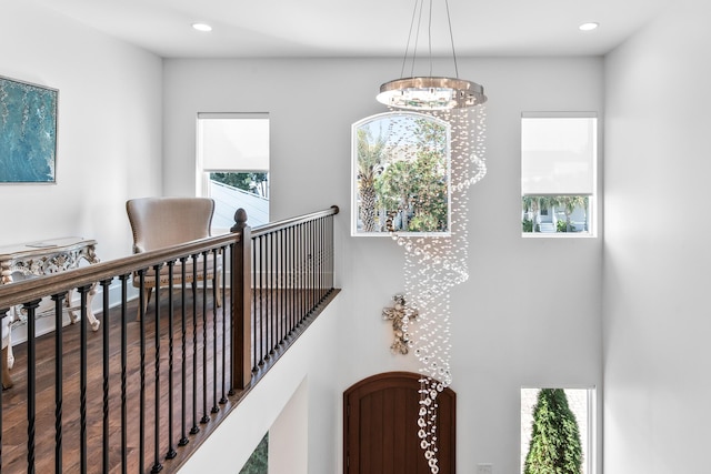 hallway featuring recessed lighting, a notable chandelier, an upstairs landing, and wood finished floors