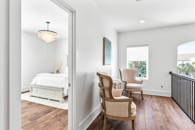 living area with recessed lighting, wood finished floors, an inviting chandelier, and baseboards