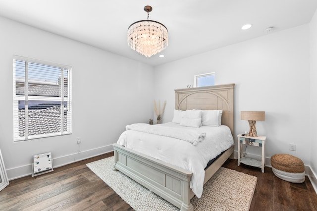 bedroom featuring multiple windows, baseboards, and wood finished floors