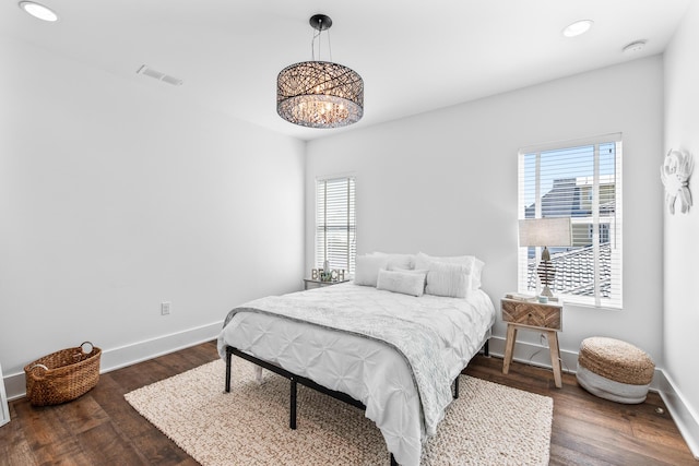 bedroom with dark wood-style floors, visible vents, baseboards, and multiple windows