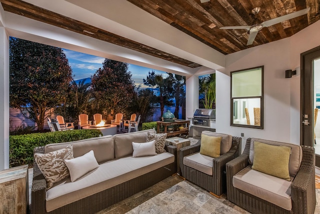 view of patio with a grill, an outdoor kitchen, a ceiling fan, and an outdoor living space with a fire pit