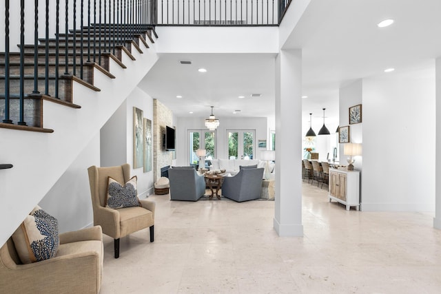 living room featuring a towering ceiling, stairway, baseboards, and recessed lighting