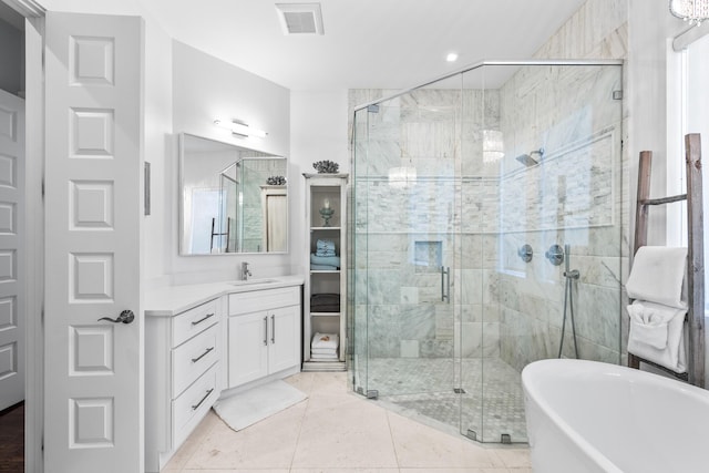 full bathroom with a stall shower, a freestanding tub, visible vents, and vanity