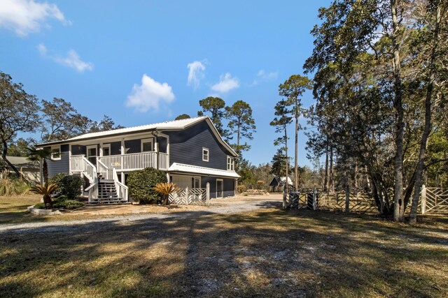 8840 Sand Pine Dr, Navarre, FL 32566 - exterior space with dirt driveway, a yard, a porch, and stairs