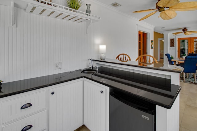 8840 Sand Pine Dr, Navarre, FL 32566 - kitchen featuring dark countertops, visible vents, ornamental molding, white cabinetry, and a sink