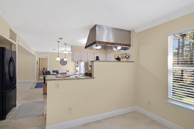 8840 Sand Pine Dr, Navarre, FL 32566 - kitchen featuring decorative light fixtures, freestanding refrigerator, wall chimney range hood, a peninsula, and baseboards
