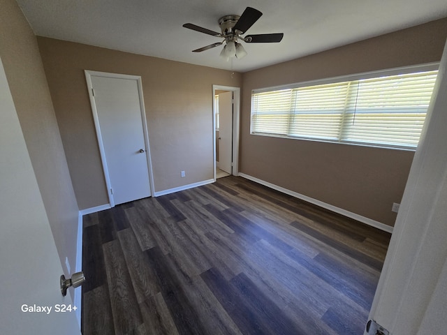 unfurnished bedroom featuring ceiling fan, dark wood-type flooring, and baseboards