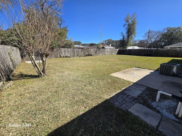 view of yard featuring a fenced backyard, a patio, and central AC unit