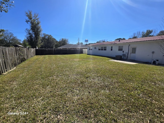 view of yard featuring a patio area, a fenced backyard, and central AC unit