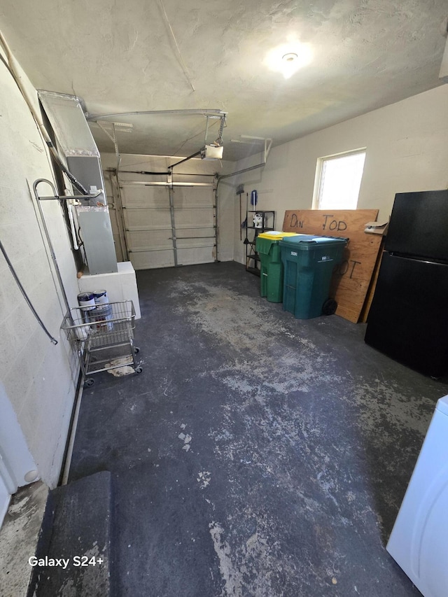 garage featuring freestanding refrigerator and a garage door opener