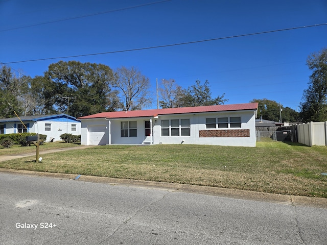 view of front of home featuring brick siding, an attached garage, a front yard, metal roof, and fence