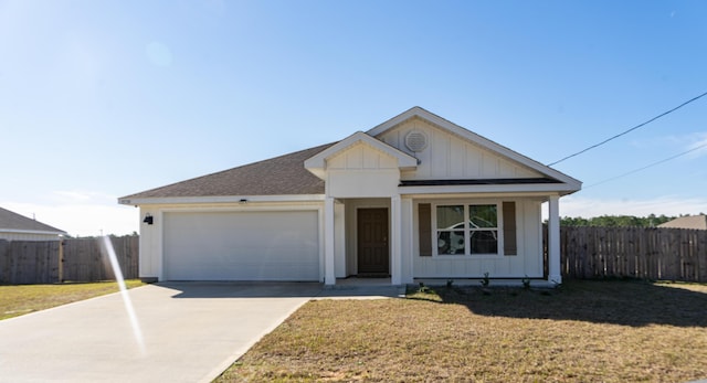 view of front of house with an attached garage, fence, board and batten siding, and a front yard