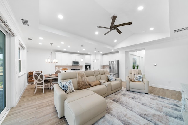 living room with visible vents, baseboards, recessed lighting, light wood finished floors, and ceiling fan with notable chandelier