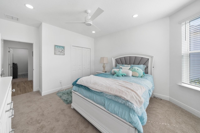 bedroom with visible vents, recessed lighting, light carpet, and a closet
