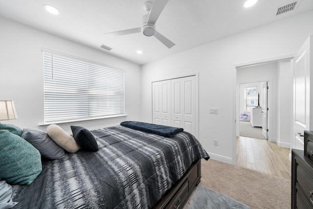 bedroom with visible vents, a closet, light colored carpet, and recessed lighting
