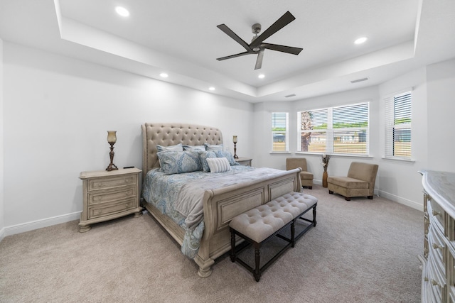 bedroom with ceiling fan, a tray ceiling, baseboards, recessed lighting, and light carpet