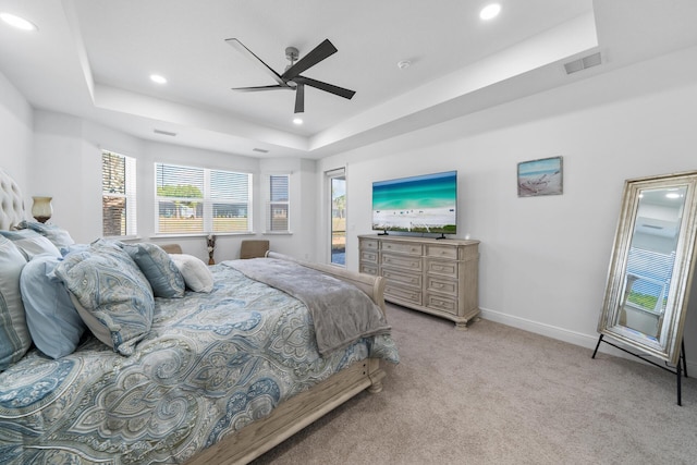 bedroom featuring recessed lighting, light carpet, baseboards, visible vents, and a raised ceiling