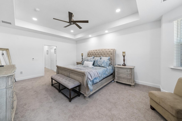 carpeted bedroom featuring recessed lighting, a tray ceiling, a ceiling fan, visible vents, and baseboards