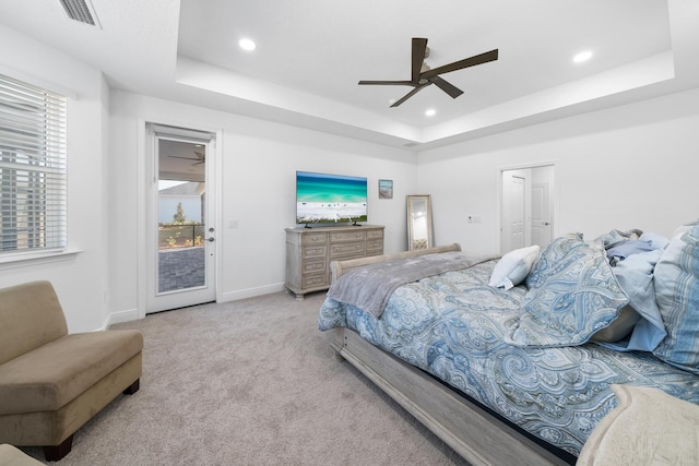 carpeted bedroom with recessed lighting, access to outside, baseboards, visible vents, and a tray ceiling