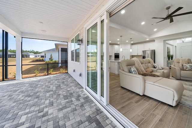 sunroom with a wealth of natural light, ceiling fan, and a sink