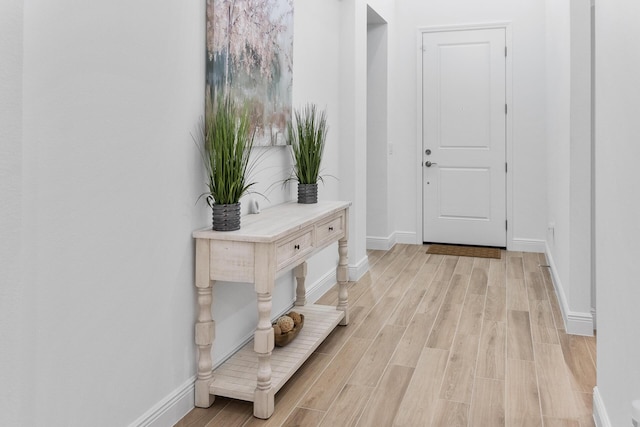 interior space featuring baseboards and light wood finished floors