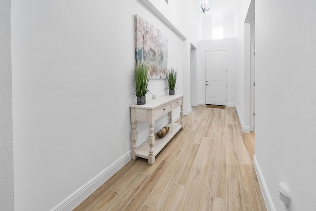 corridor featuring baseboards and light wood-style floors