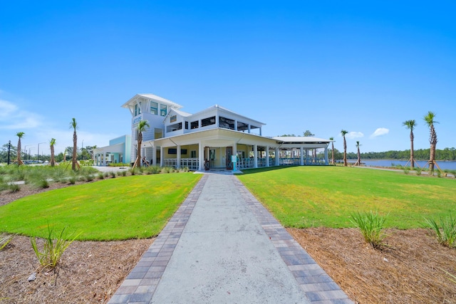 surrounding community with a water view and a yard