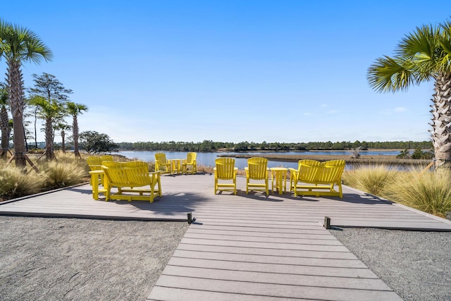 wooden deck with a dock and a water view