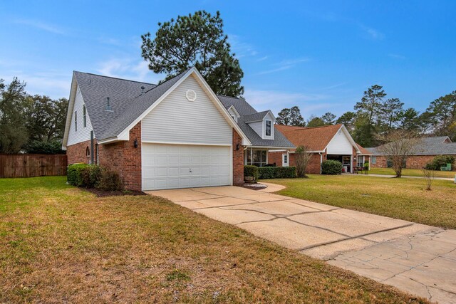 view of front of house featuring a garage, a front yard, concrete driveway, and brick siding