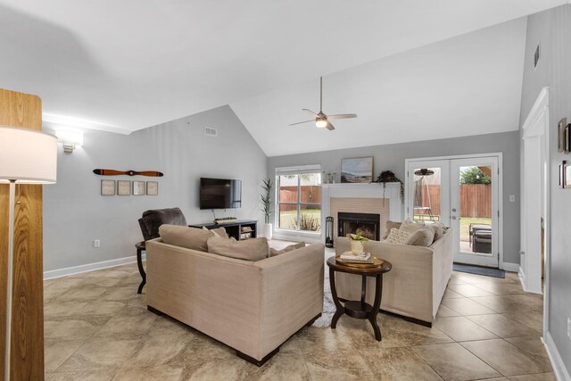 living area featuring light tile patterned floors, baseboards, ceiling fan, french doors, and a brick fireplace