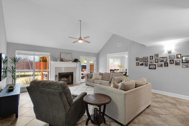 living room featuring visible vents, a ceiling fan, a brick fireplace, high vaulted ceiling, and baseboards