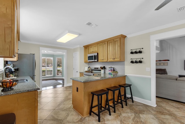 kitchen featuring stainless steel appliances, a sink, visible vents, ornamental molding, and tasteful backsplash