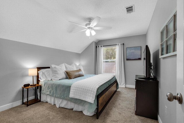 carpeted bedroom with baseboards, visible vents, a ceiling fan, vaulted ceiling, and a textured ceiling