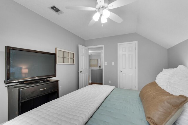 bedroom with a ceiling fan, visible vents, and vaulted ceiling