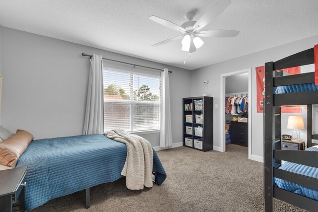 bedroom with a textured ceiling, carpet floors, a ceiling fan, and baseboards