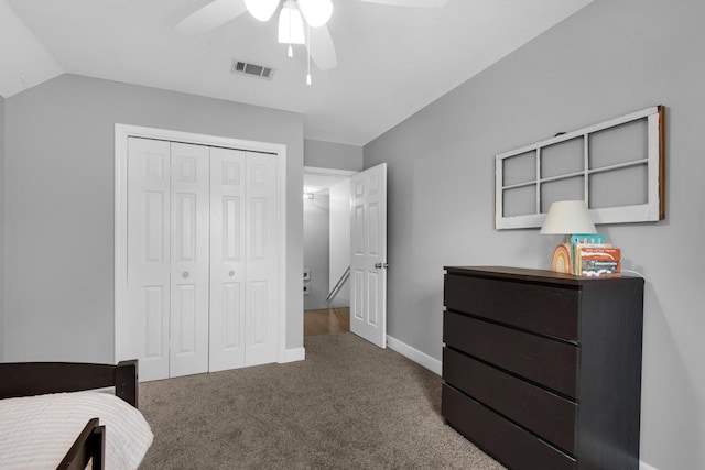 carpeted bedroom featuring lofted ceiling, a closet, visible vents, ceiling fan, and baseboards