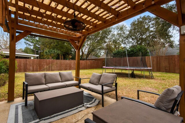 view of patio featuring a trampoline, a fenced backyard, an outdoor living space, and a pergola