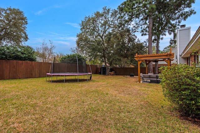 view of yard with a trampoline, a fenced backyard, and a pergola