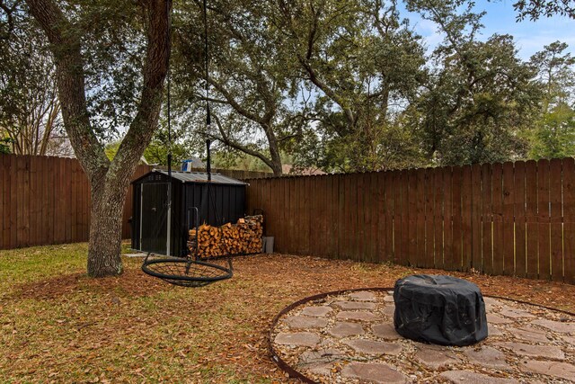 view of yard featuring a shed, a fenced backyard, and an outdoor structure