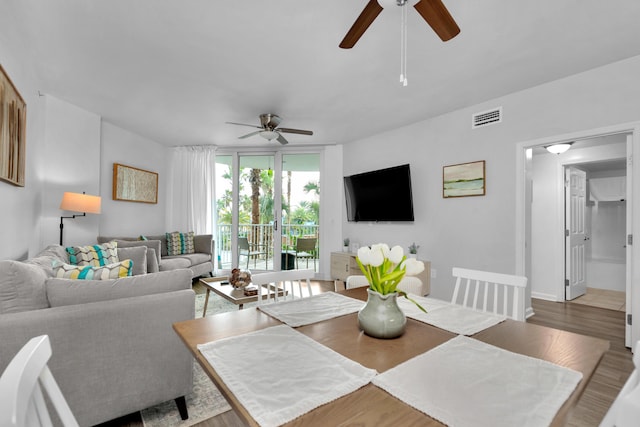 dining area with a ceiling fan, baseboards, visible vents, and wood finished floors