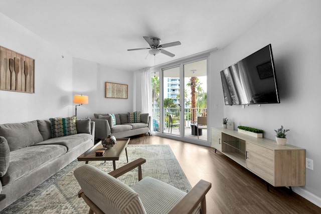 living room featuring a ceiling fan, a wall of windows, and dark wood-type flooring