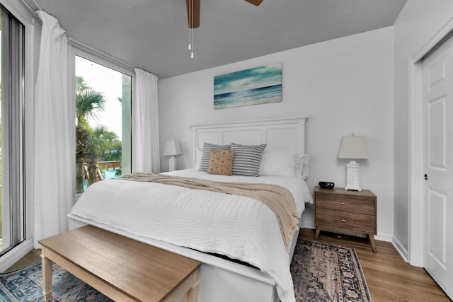 bedroom featuring ceiling fan, baseboards, and wood finished floors