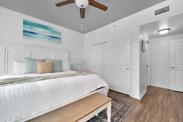 bedroom featuring baseboards, visible vents, ceiling fan, wood finished floors, and a closet