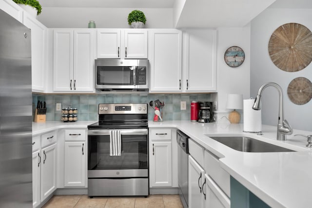 kitchen with stainless steel appliances, light countertops, a sink, and backsplash