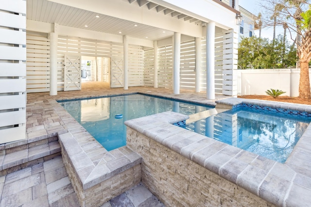 view of pool featuring fence and an in ground hot tub