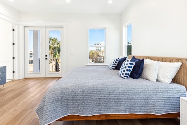 bedroom featuring access to exterior, french doors, wood finished floors, and recessed lighting