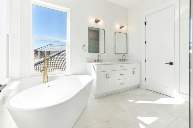 full bath featuring a freestanding tub, a sink, and double vanity