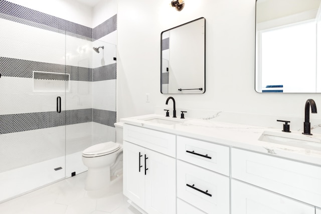 bathroom featuring double vanity, a sink, toilet, and a shower stall