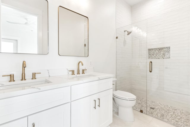 full bathroom with toilet, a shower stall, double vanity, and a sink