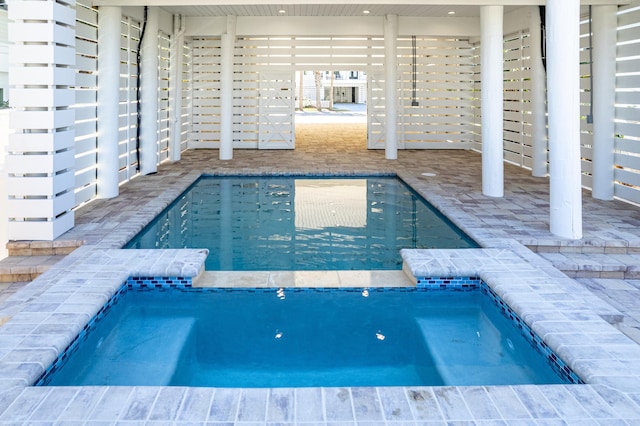 view of swimming pool featuring a patio and a pool with connected hot tub